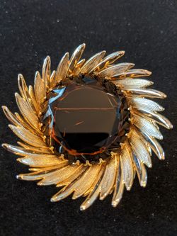 $10. Vintage amber colored gold tone brooch. Brooch is 2 in in diameter. Great condition. No fading.