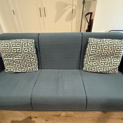 Blue Sleeper Sofa With Geometric Pillows