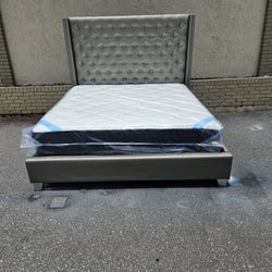 Silver King Size Sofia Vergara Upholstery Bed Frame With Brand New King Size Plush Pillow Top DreamCloud Premier Hybrid Mattress and Box In Plastics