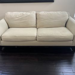 Tan Sofa With Dark Wooden Base 