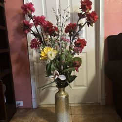 tall, decorative vase filled with an arrangement of artificial flowers