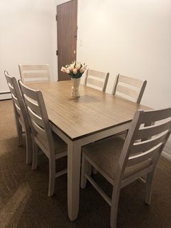 rustic farmhouse dining table set with six matching ladder-back chairs and upholstered seats