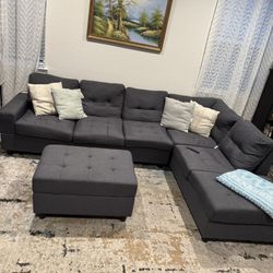 Gray couch w a cup holder and ottoman