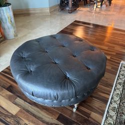 Gray faux leather tufted ottoman w/nailhead trim & wooden legs on casters - 36” D