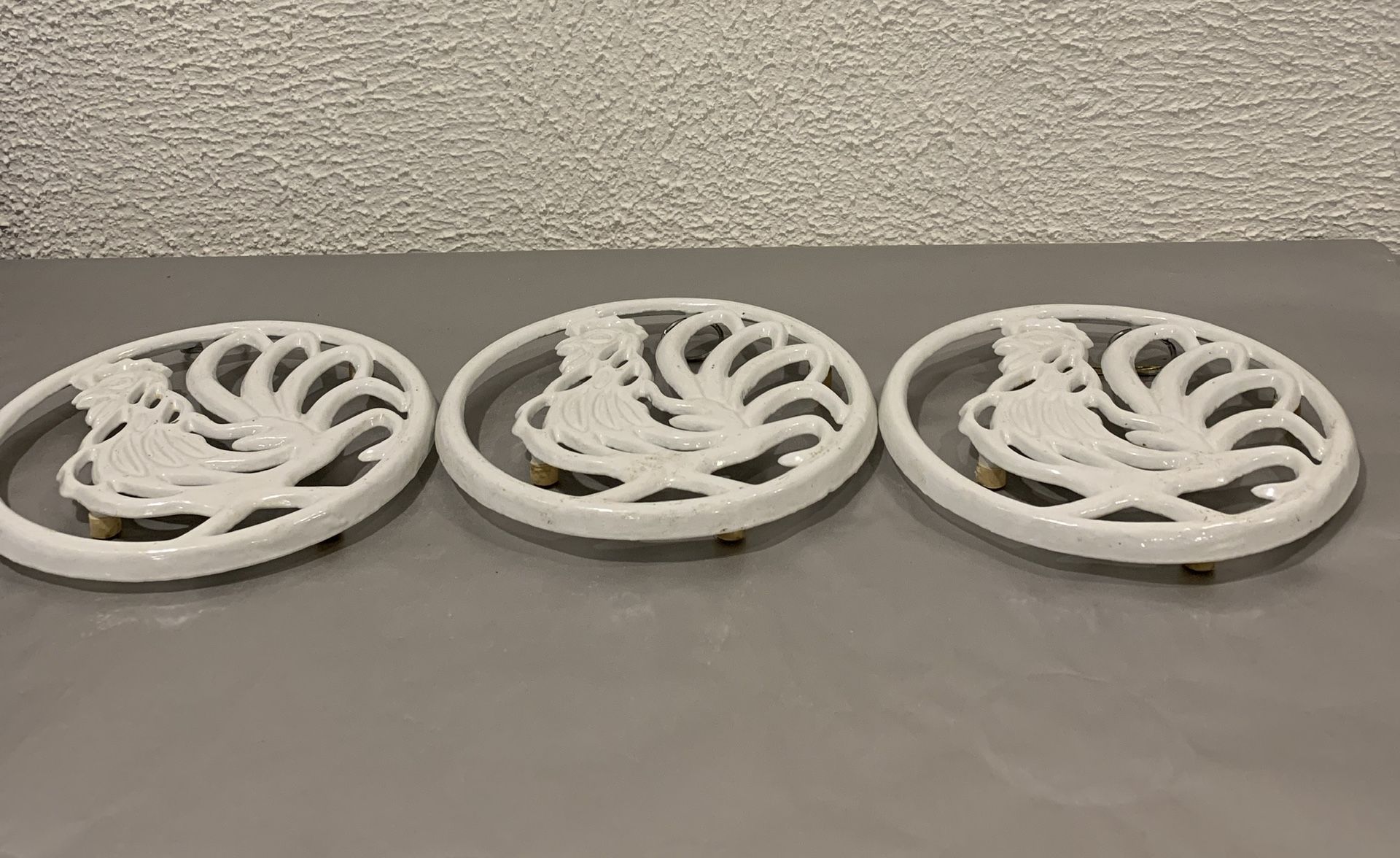 A collection of 3 vintage 1996 trivet cast iron roosters with hanging loop 7.50” long and 7” wide If you see it here , it is available Local pick up