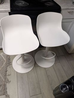 modern adjustable monochromatic white swivel barstools, featuring an ergonomic molded low-back shell design, a central pedestal hydraulic lift, and a 