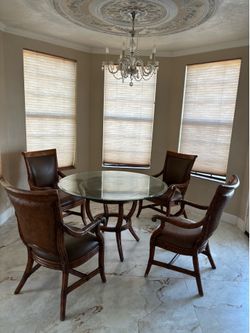 Round glass top table with bamboo base and 4 bamboo chairs with leather cushions