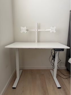 White electric standing desk with monitor mount