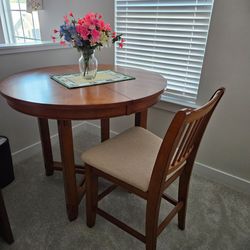 Solid oak high top table, 4 cushioned chairs & leaf