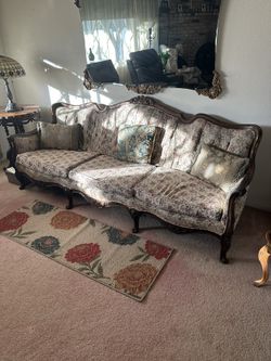 Vintage French Provincial style floral couch with carved wood trim.