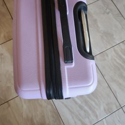 A suitcase, which is a type of luggage used for traveling. The specific item appears to be a light purple, hard-shell, wheeled model. suitcase is desi