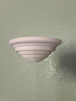 Two whitish ceramic sconce lights can be painted