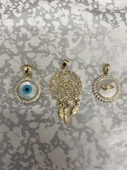 Yellow 14kt dream catcher and evil eye.