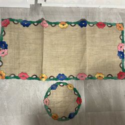 a set of vintage hand-stitched floral appliqué table linens, including a runner and a round placemat. 