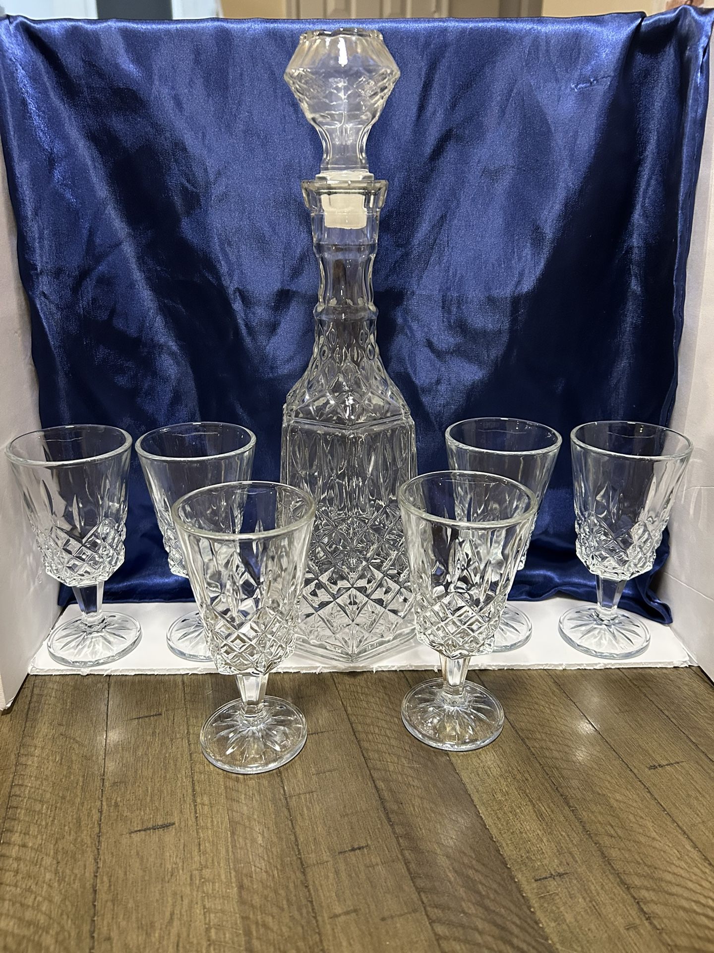 This is a vintage diamond-cut glass decanter with a stopper. The decanter has a diamond-cut molded glass pattern, which is a common feature of mid-ce