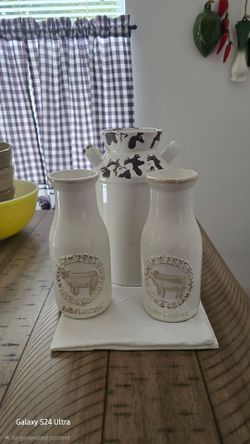 Ceramic milk container with two Ceramic milk bottles and a metal holder