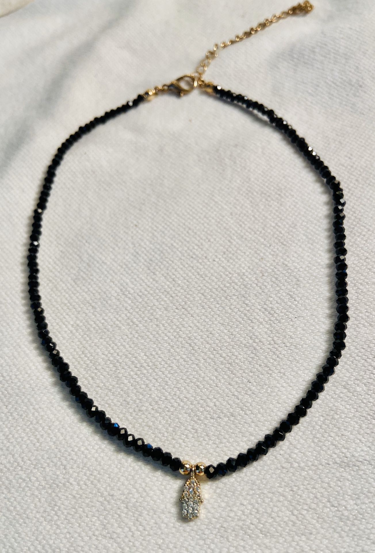 BLACK CRYSTALS WITH GOLD TONE NECKLACE W/HAND 15”