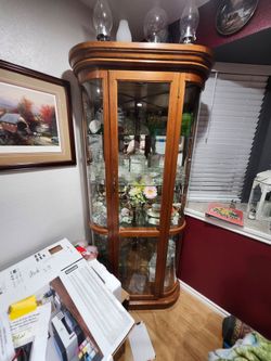 Corner curio cabinet with curved glass