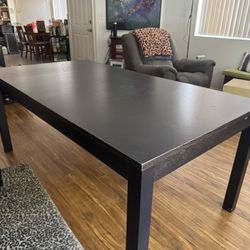 Dark brown wood dining table with two leaves
