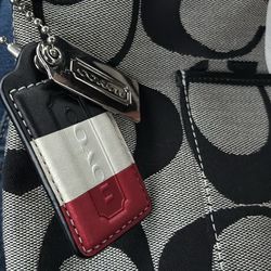 Coach Hampton Weekend Signature Stripe Hobo bag featuring a black and grey signature canvas pattern with red and white stripes