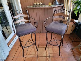 Two tall iron bar stools. From seat to floor 30". Limon Bryson model by Powell Furniture, featuring a powder-coated bronze finish and a swivel padded 