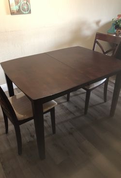 Brown dining table with two chairs