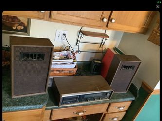 XAM Vintage Model SH-88 stereo receiver with an 8 track player and AM/FM radio from 1964. Wood grain paneling and classic slider controls for volume.
