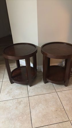 Two round brown end tables