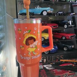 This is a Strawberry Shortcake Orange Blossom straw tumbler with a handle, often a BoxLunch Exclusive. 