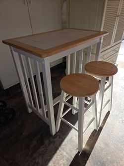 3 Piece Set Bar height table with 2 chairs, in good condition.  Table measures 34" tall x  21 1/2" wide x 33 1/2" long. Bar stools are 24" tall. $130.