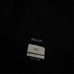 black zip-up hoodie with white cross-style graphic
