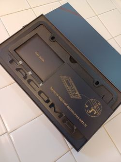 Toyota Tacoma black license plate frame one piece. Black frame with Raised lettering.