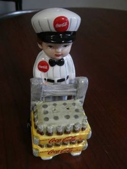 Vintage coca cola porcelain delivery man salt and pepper shakers and gas pump shakers both never used located in palm springs ca excellent