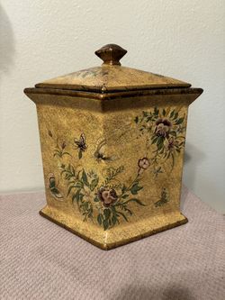 Diamond-shaped, footed ceramic jar with a lid. 
