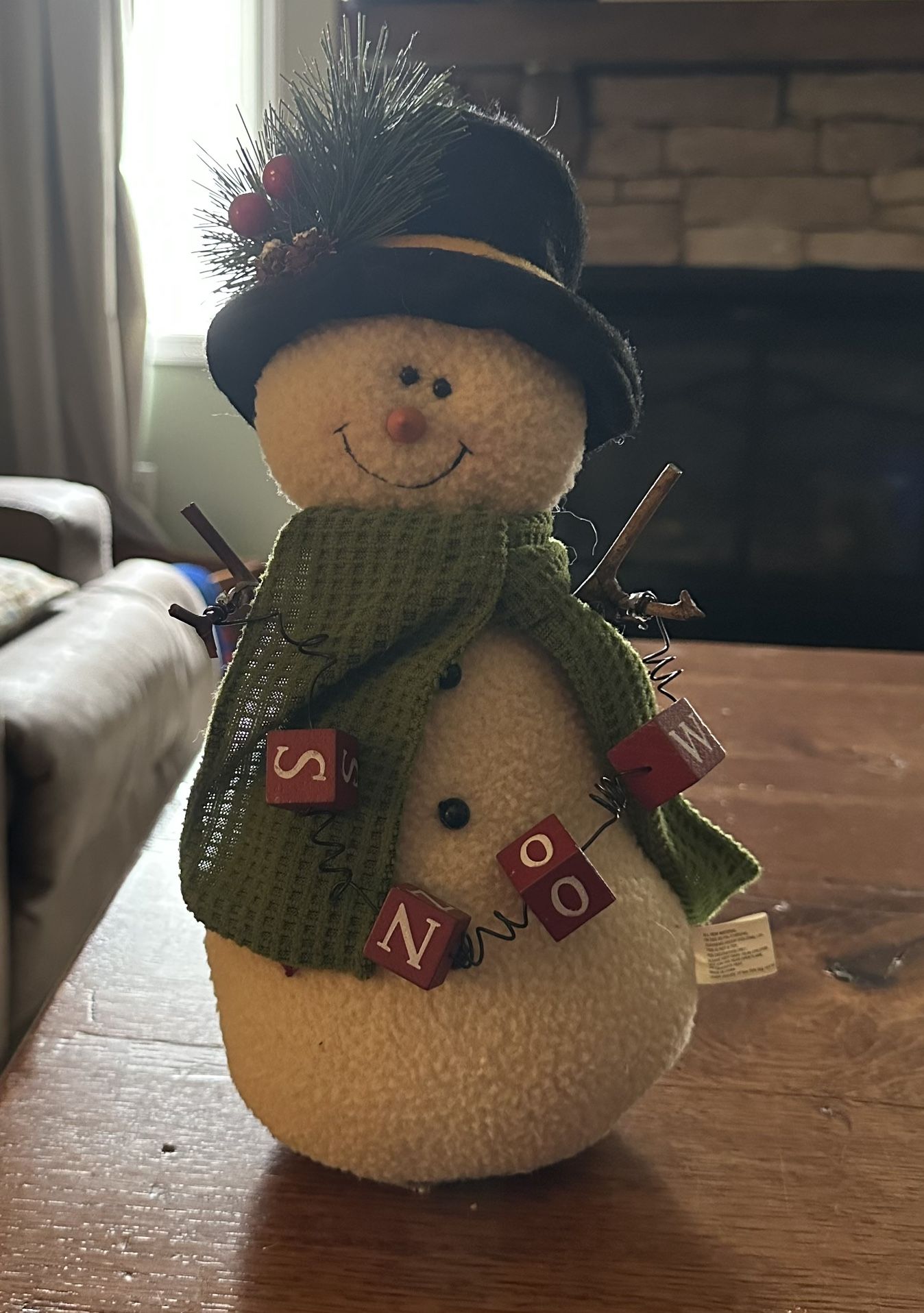 Plush snowman holding block letters