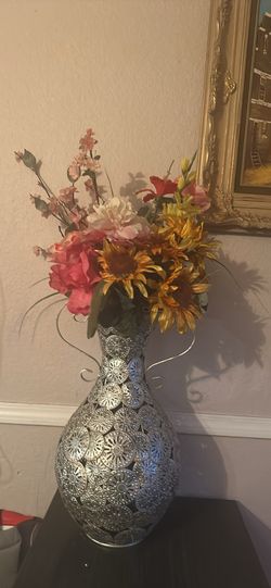 Metal vase with flowers.