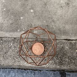 This is a modern geometric copper metal candle holder. 