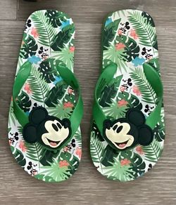 Disney Mickey Mouse tropical flip-flops feature a green palm tree print and a large Mickey Mouse icon on the green straps