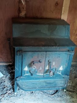 wn in the image is a vintage Fisher "Grandma Bear" wood-burning stove, a highly durable cast-iron model produced during the 1970s and 1980s.