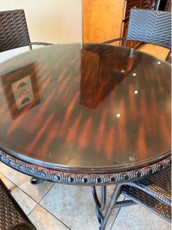 Round dining table with 5 chairs. Wooden with glass top and wicker chairs!