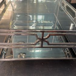 Beautiful, Contemporary coffee table with a glass top and a mirrored bottom surrounded by a chrome frame