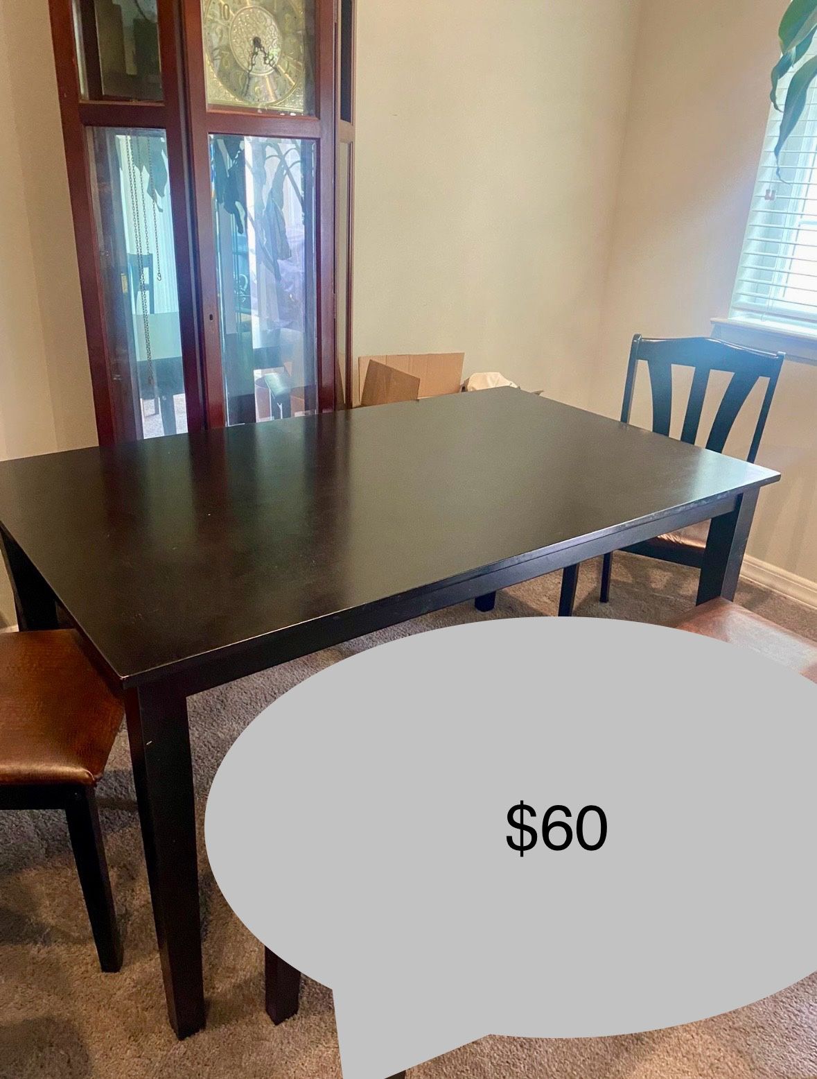 Black wood dining room table with 4 black chairs and one bench