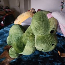 dinosaur plush stuffed animal with pink bunny ears. 