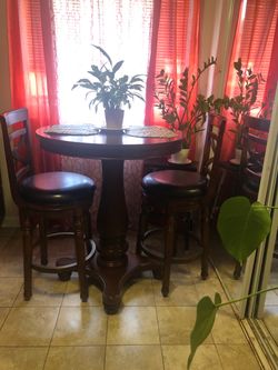 Real wood Dinning set : high round  Table and two leather high  chairs . Delivery available