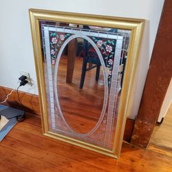 Gold framed mirror with flower design