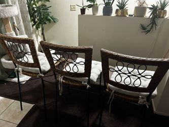 Three counter-height chairs feature woven