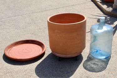 A large terracotta cylinder in near new condition + a made in Italy very sturdy terracotta saucer