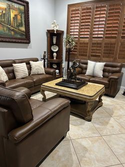 Brown genuine leather sofa, loveseat and chair.