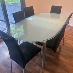 Glass Top Table With Build In Extension And 6 Chairs That Have Removable Covers