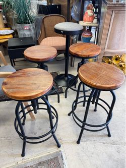 Set of 4 Industrial counter stools featuring round solid wood seats and adjustable black metal bases